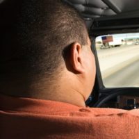 Male truck driver traveling on a highway