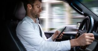 man using cell phone while driving